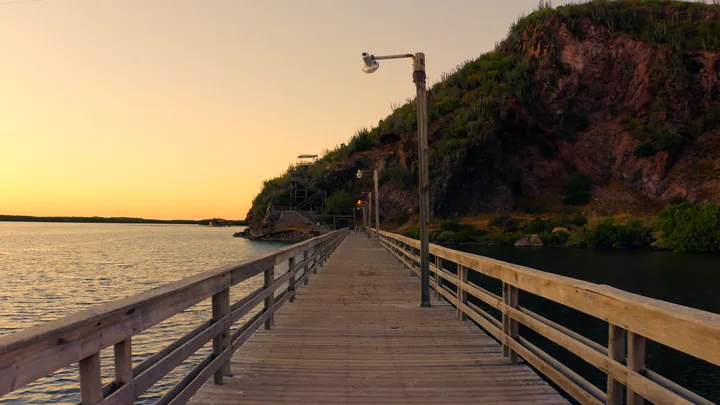 Andador de madera sobre el agua al atardecer