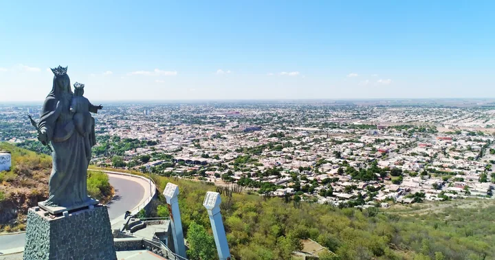 Estatua de la Virgen del Valle en un mirador elevado con panorámica de la ciudad al fondo